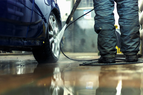 Contractor Washing Car With High Pressure